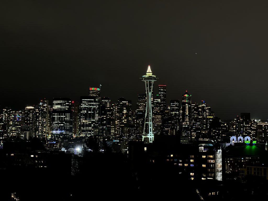 Seattle skyline at night with Space Needle in center, with Christmas lights on top